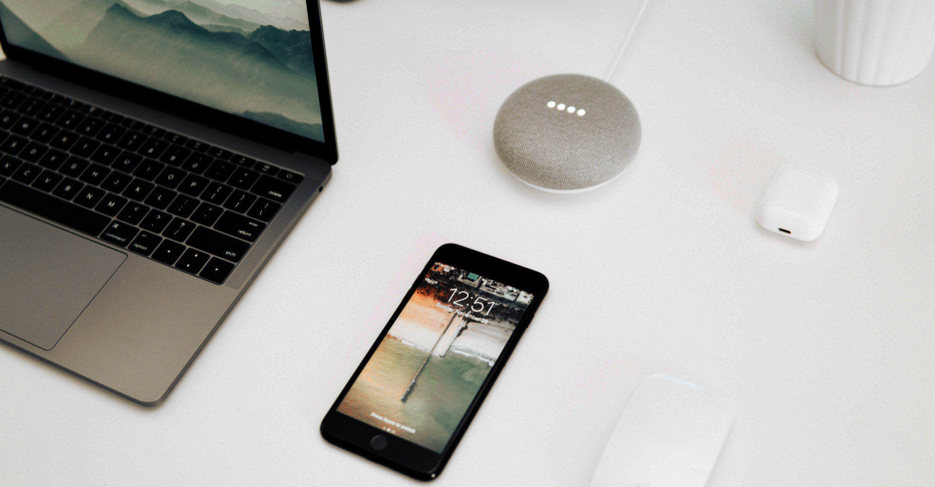 Google Smart Home Mini, ein Laptop und ein Smartphone